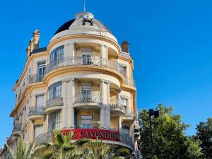 a tall white building with a sign on it at Le Cavendish in Cannes
