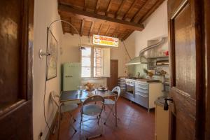 una cucina con tavolo e sedie in una stanza di Mamo Florence - Artemisia Apartment a Firenze