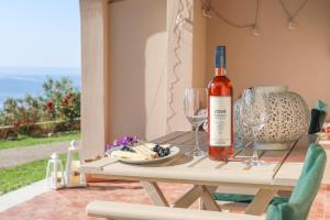 a bottle of wine sitting on a table with wine glasses at Tramontana House2 in Skiathos
