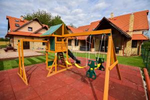 un columpio de madera en el patio de una casa en Bakonyi Mesekastély, en Olaszfalu