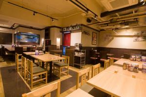 an empty restaurant with wooden tables and chairs at Ochanomizu Inn in Tokyo
