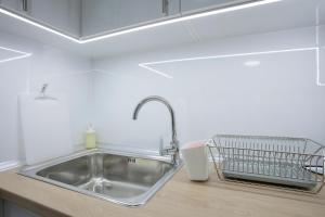 a kitchen sink with a dish drying rack next to it at Landmark 1BDR Apartment in Center, next to Metro in Sofia +34 photos