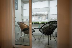 two chairs and a table in a room with a window at Landmark 1BDR Apartment in Center, next to Metro in Sofia
