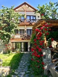 una casa con fiori rossi davanti di Hotel Chubu a Mestia