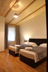 una camera da letto con due letti e una finestra di Hotel Chubu a Mestia