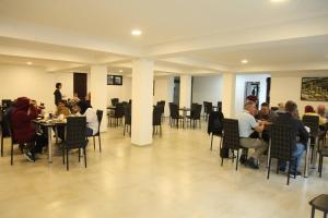 un gruppo di persone seduti ai tavoli in un ristorante di Hotel Chubu a Mestia Altre 31 foto