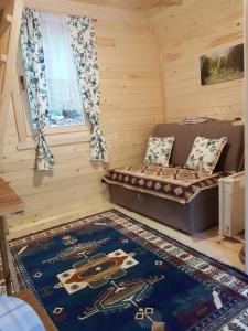 Kleines Zimmer mit einem Bett und einem Teppich in der Unterkunft Bungalows Prokletije in Gusinje