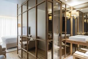 La salle de bains est pourvue d'un grand placard en verre avec un lavabo. dans l'établissement Casa da Companhia Hotel, Vignette Collection, à Porto