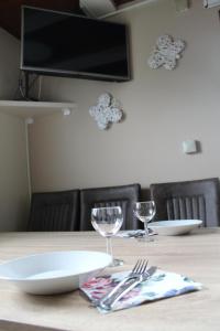 a wooden table with two plates and glasses on it at Hiška Čatež in Brežice