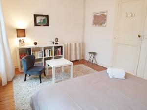 um quarto com uma cama, uma cadeira e uma estante de livros em Maison de ville confortable avec cour interieure em Angoulême