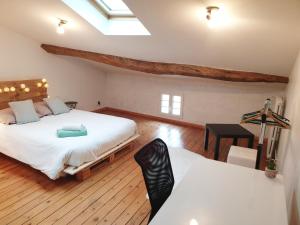 a bedroom with two beds and a desk in it at Maison de ville confortable avec cour interieure in Angoulême