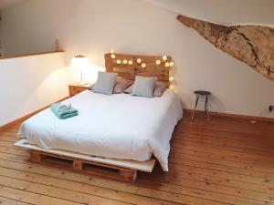 a bedroom with a white bed with a wooden headboard at Maison de ville confortable avec cour interieure in Angoulême +26 photos