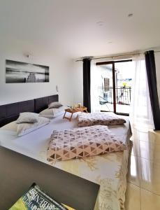 two beds in a room with a large window at Pansion Makina in Vodice