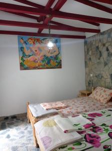 a bedroom with a bed and a painting on the wall at La Actoru` in Vama Veche +30 photos