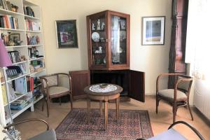 a living room with a table and chairs and a book shelf at Casa familiar decimonónica con mucho encanto in Sant Feliu de Guíxols