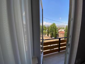 Une porte ouverte s'ouvre sur un balcon avec vue. dans l'établissement Nikas apartment with balcony in old Tbilisi, à Tbilissi