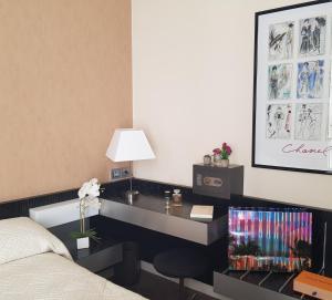 1 dormitorio con escritorio, cama y lámpara en HOTEL ALISON en París