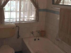 a bathroom with a tub and a sink and a window at Goederus Guest Farm in Sterkspruit +16 photos