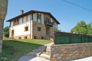 a large stone house with a fence in front of it at Casa Aingeru in Carranza