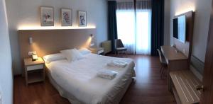 Una habitación de hotel con una cama con dos toallas. en Hotel Vejo en Reinosa