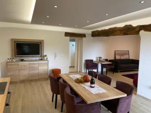 a living room with a table and chairs and a television at Villa Sanela in Pobegi