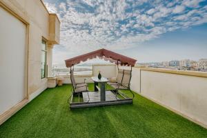 a balcony with a table and chairs on a roof at Elite Al Hamra - Al Cornich in Jeddah