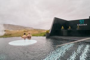 two men standing in a pool of water at Stóraborg Holiday Home in Storaborg