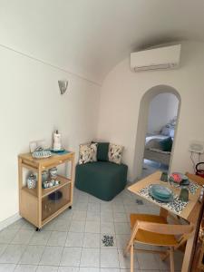 a living room with a green couch and a table at Suite Antimo - Casa Scibetta in Positano