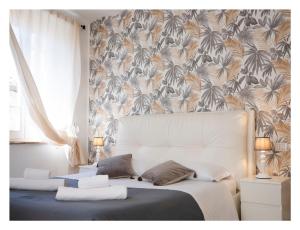 a bedroom with a white bed with a floral wallpaper at RESIDENCE IL GROTTINO in Gualdo Cattaneo