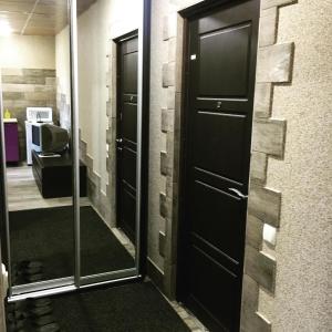 korytarz z dwoma czarnymi drzwiami i lustrem w obiekcie Апартаменты в центре Кривого Рога w mieście Krzywy Róg