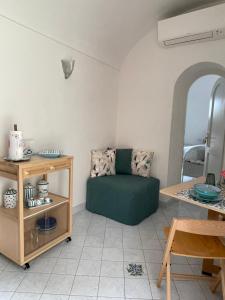 a living room with a green couch and a table at Suite Antimo - Casa Scibetta in Positano