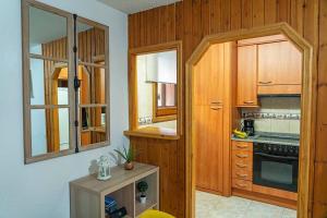 une cuisine avec des armoires en bois et un four à plaques de cuisson dans l'établissement PROBER_NEVADA II, au Pas de la Case