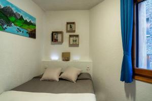 une chambre avec un lit, des rideaux bleus et une fenêtre dans l'établissement PROBER_NEVADA II, au Pas de la Case