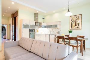 a living room and kitchen with a couch and a table at Spacious apartment with cozy balcony by URBAN RENT in Vilnius