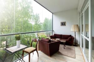 Spacious apartment with cozy balcony by URBAN RENT في فيلنيوس: غرفة معيشة مع أريكة وطاولة