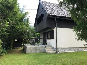 a black and white house with a bench in a yard at Holiday Home Anja in Bohinj
