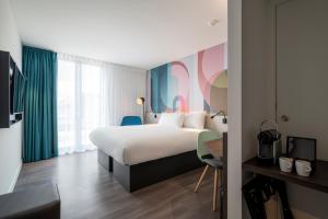 a hotel room with a large bed and a large window at B&B HOTEL Gent Centrum in Ghent