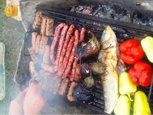 a bunch of meats and fish on a grill at La Actoru` in Vama Veche