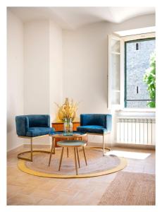 a living room with two blue chairs and a coffee table at Il Grottino Relais & Spa in Gualdo Cattaneo