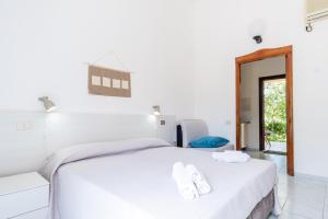 a bedroom with a white bed with white towels on it at Residence Cort'e Accas in Bari Sardo