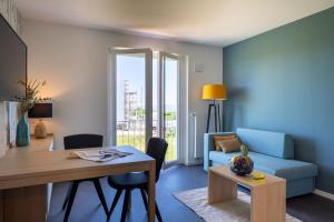 a living room with a blue couch and a table at KONCEPT HOTEL Neue Horizonte in Tübingen