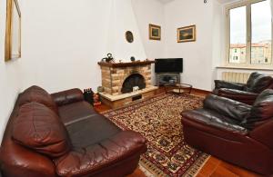 a living room with two leather couches and a fireplace at Borgo 98 Guest House Matrimoniale con bagno privato in Livorno