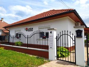 una pequeña casa blanca con una puerta negra en Tulipán Vendégház, en Sárospatak