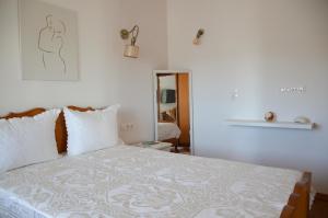 a bedroom with a large bed with white sheets at Rhyolite Apartment in Triovasálos