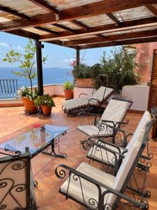 a patio with chairs and a table and a view of the ocean at Suite Antimo - Casa Scibetta in Positano +16 photos