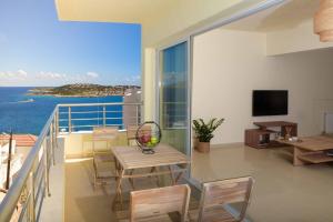 d'un balcon avec une table et des chaises donnant sur l'océan. dans l'établissement Oikies Luxury Apartments with private free parking area, à Agios Nikolaos