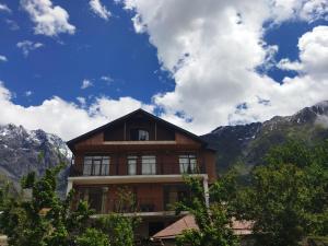 a large building with mountains in the background at DISCOVER KAZBEGi HOTEL in Kazbegi