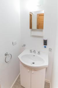 a white bathroom with a sink and a mirror at Edificio Pampa II in Añelo +27 photos
