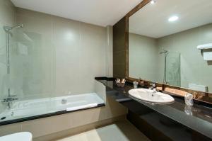y baño con bañera, lavamanos y bañera. en Motel Cancun Avilés, en Iboya