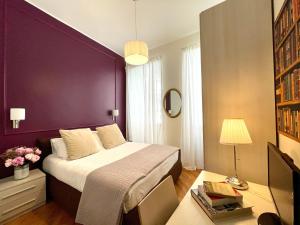 ローマにあるBanchi Vecchi Stayの紫の壁のベッドルーム1室(ベッド1台付)